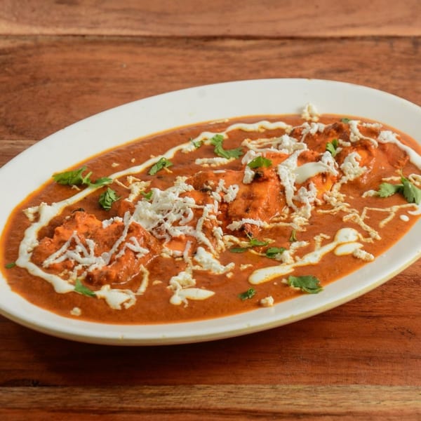Kadhai Indian Cuisine's paneer butter masala, a rich orange curry with paneer, cream, and cilantro.