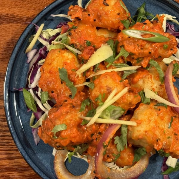 Kadhai Indian Cuisine's Gobi Manchurian, a vibrant dish of fried cauliflower in a spicy red sauce.